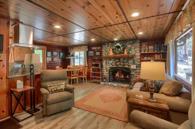 a living room with a stone fireplace in a house at Chipmunks Holiday in Wawona