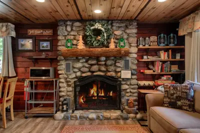 a living room with a stone fireplace in a house at Chipmunks Holiday in Wawona