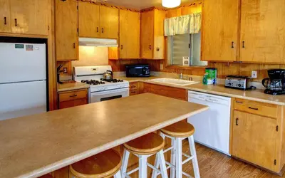 a kitchen with white appliances and wooden cabinets at Longview at The Redwoods in Wawona