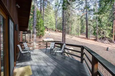 a deck with chairs and a table on a house at Tyler's Timber Lodge in Wawona