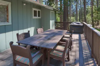 a wooden table and chairs on a deck at New Beginnings at The Redwoods Cabin in Wawona