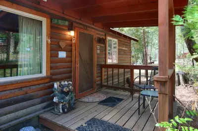 a front porch of a log cabin with a door at Le Fawn in Wawona