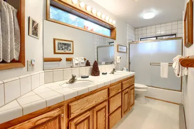 a bathroom with a sink and a toilet and a window at Pohono Pines in Wawona