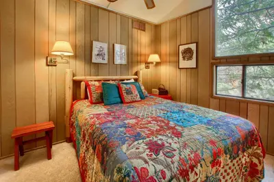 a bedroom with a bed with a colorful comforter at Pohono Pines in Wawona