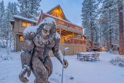 a statue of a bear in the snow in front of a house at Big Foots Den on the 10 Northstar Resort Truckee in Truckee