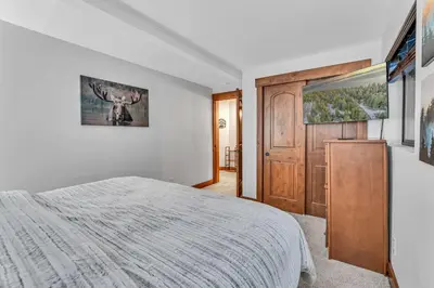 a bedroom with a bed and a wooden door at Big Foots Den on the 10 Northstar Resort Truckee in Truckee