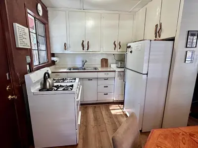 a kitchen with white appliances and a white refrigerator at Heart of the Meadow in Wawona