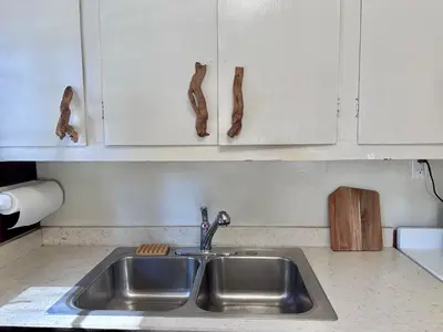 a kitchen with a sink and white cabinets at Heart of the Meadow in Wawona