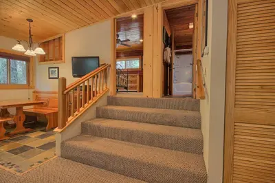 a staircase in a home with a desk and a television at The Tree House in Wawona