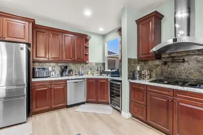 a kitchen with wooden cabinets and stainless steel appliances at Game Lovers Retreat, spacious 4000 sqft Getaway in El Dorado Hills