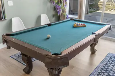 a pool table with a cue ball on top of it at Game Lovers Retreat, spacious 4000 sqft Getaway in El Dorado Hills