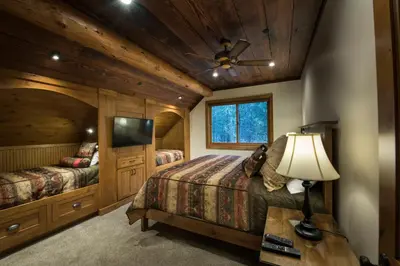 a bedroom with two beds and a flat screen tv at Rustic Retreat in Wawona