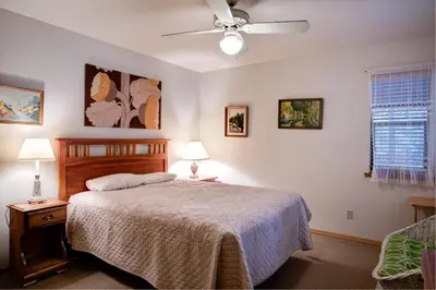 a bedroom with a bed and a ceiling fan at Cecil's Cabin in Wawona