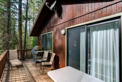 a screened in porch with a table and chairs at Cecil's Cabin in Wawona