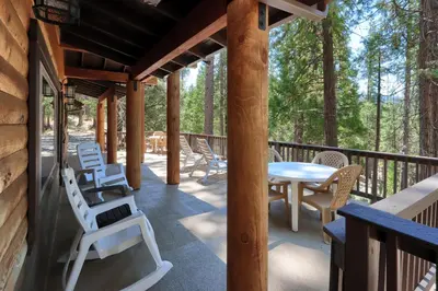 a patio with chairs and a table on a deck at Bradley's Cabin in Wawona