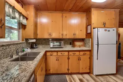 a kitchen with wooden cabinets and a white refrigerator at Bradley's Cabin in Wawona