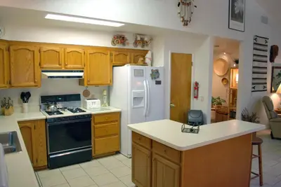 a kitchen with wooden cabinets and a white refrigerator at Big Cedar in Wawona