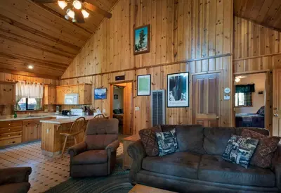 a living room with a couch and a kitchen at Wawona Cabin in Wawona