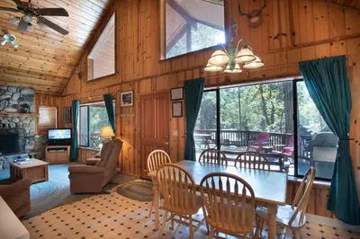 a dining room and living room with a table and chairs at Wawona Cabin in Wawona