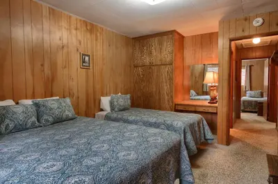 a bedroom with two beds and a table and a mirror at Villarreal Retreat in Wawona