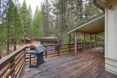 a wooden deck with a grill on the side of a house at Villarreal Retreat in Wawona