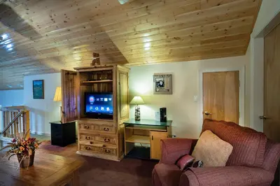 a living room with a couch and a tv at The Terry Cabin in Wawona