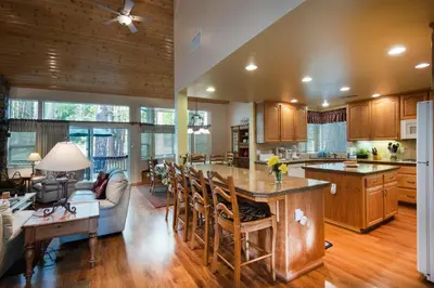 an open kitchen and living room with wooden cabinets at The Terry Cabin in Wawona
