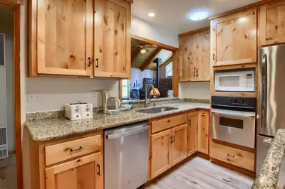 a kitchen with wooden cabinets and stainless steel appliances at Quail Meadow in Wawona