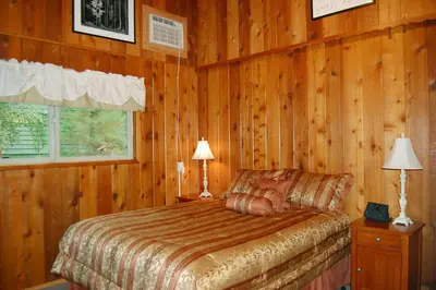 a bedroom with a bed and two lamps and a window at Dunning's Retreat in Wawona
