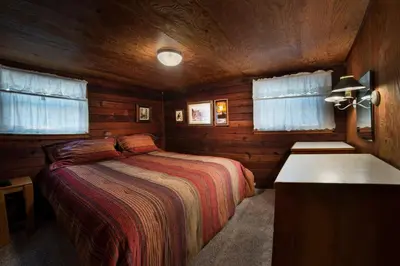 a bedroom with a bed in a wooden cabin at Grandma's Cabin in Wawona