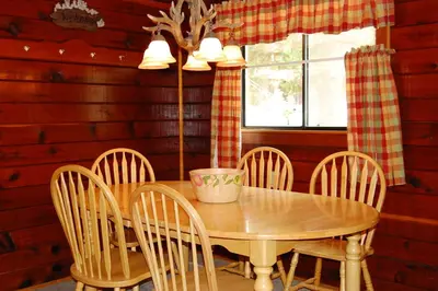a dining room with a wooden table and chairs at Cubby's Den in Wawona