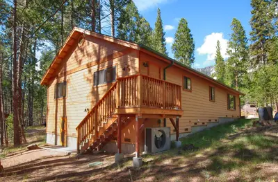 a cabin in the woods with a deck at Larkspur Lair in Wawona