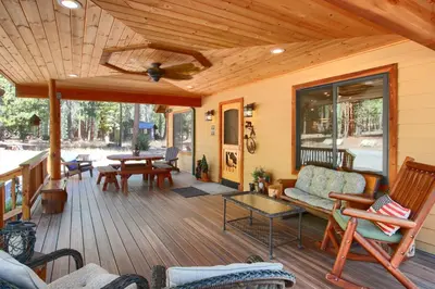 a covered porch with a couch and a table at Larkspur Lair in Wawona
