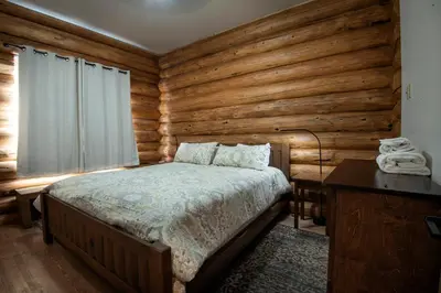 a bedroom with a bed and a wooden wall at The Mini Cabin in Wawona