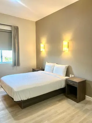 a bedroom with a large bed with white sheets and pillows at The Palisades Lodge of Big Pine in Big Pine