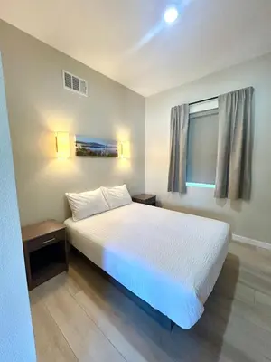 a bedroom with a white bed and a window at The Palisades Lodge of Big Pine in Big Pine