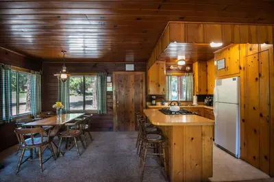 a kitchen and dining room with a table and a refrigerator at Lockwood Lodge in Wawona