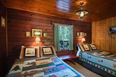 a bedroom with two beds in a log cabin at Lockwood Lodge in Wawona