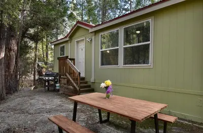 a vase of flowers on a picnic table in front of a house at Suter's Forte in Wawona