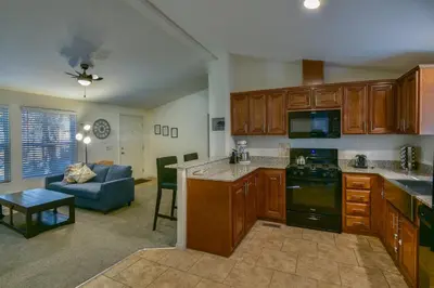 a kitchen with wooden cabinets and a living room at Suter's Forte in Wawona