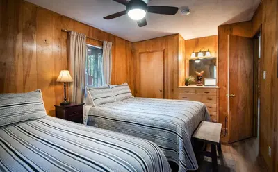 a bedroom with two beds and a ceiling fan at Pine Creek Cabin in Wawona