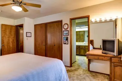 a bedroom with a bed and a flat screen tv at Coyle's Cabin in Wawona