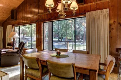 a dining room with a wooden table and a large window at Coyle's Cabin in Wawona