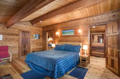 a bedroom with a bed in a wooden room at Cedar Chalet in Wawona