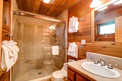 a bathroom with a shower toilet and a sink at Cedar Chalet in Wawona
