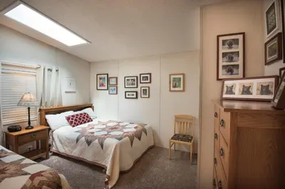 a bedroom with a bed and a dresser in it at Rosenberg's Creekside Cabin in Wawona