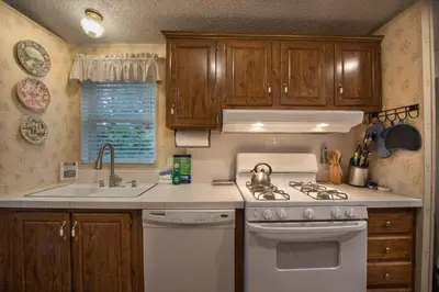 a kitchen with a white stove and a sink at Rosenberg's Creekside Cabin in Wawona