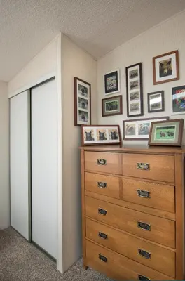 a bedroom with a dresser and pictures on the wall at Rosenberg's Creekside Cabin in Wawona