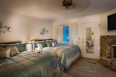 a bedroom with two beds and a tv and a fireplace at The Last Resort in Wawona