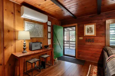a room with a bed and a television and a window at The Overlook in Wawona